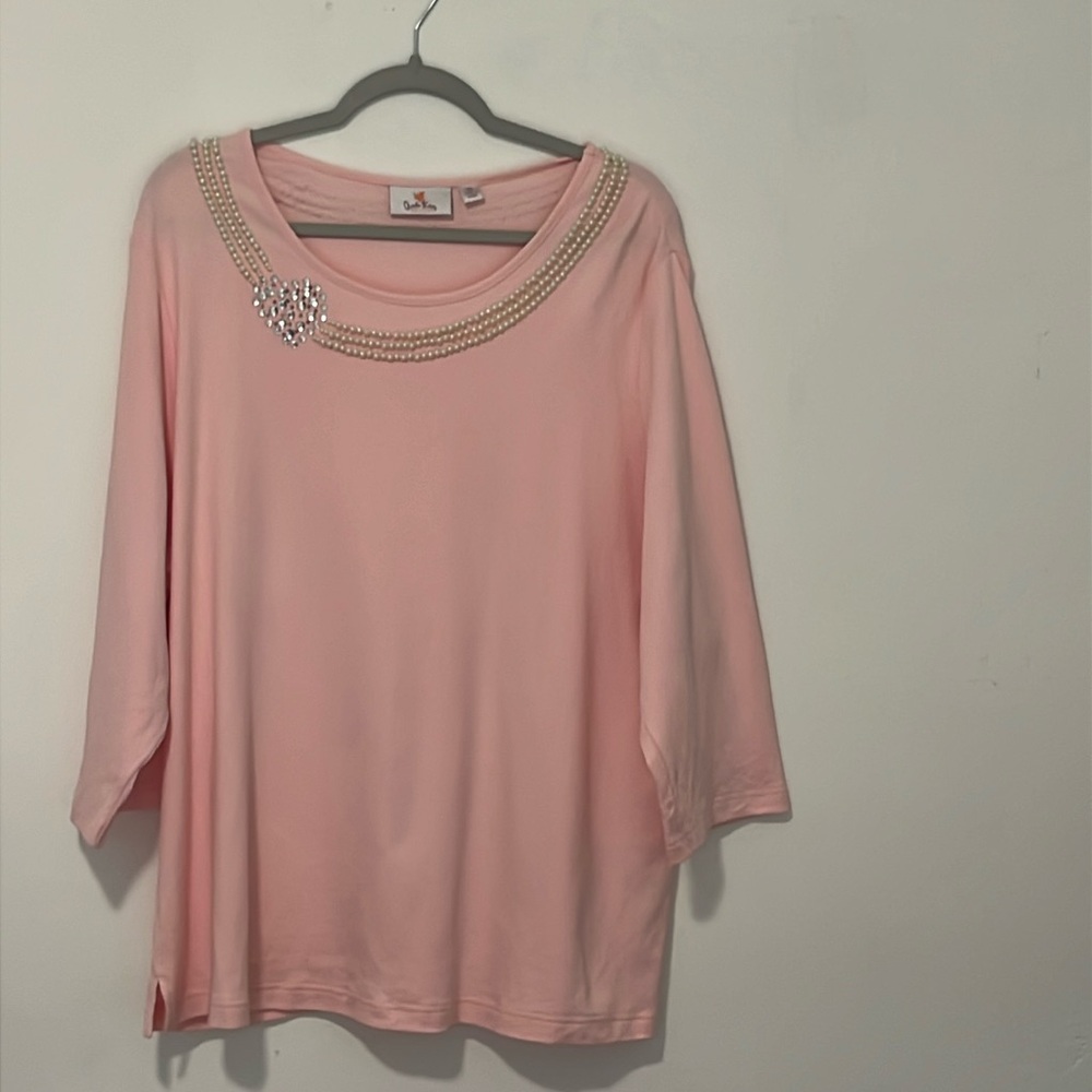 Pink top with quarter length, sleeves, rhinestones and pearls around neck.